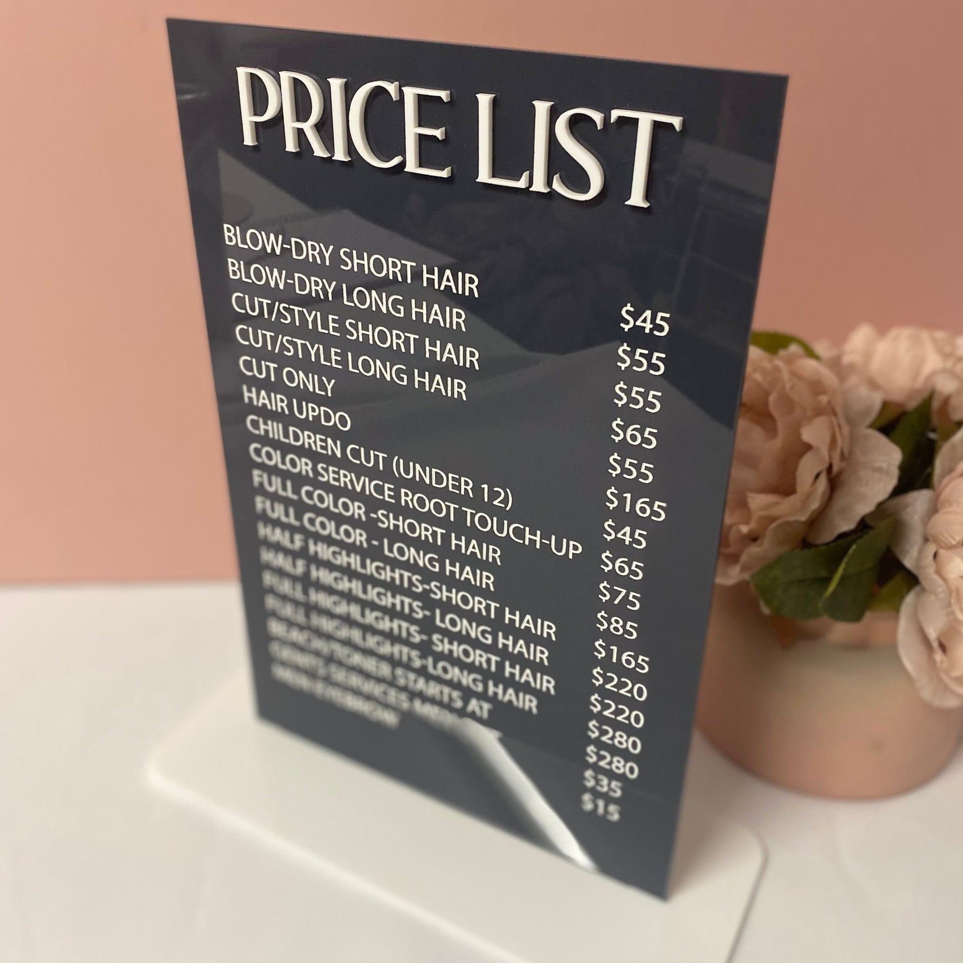 Salon price list sign in dark grey acrylic with white stand and text.