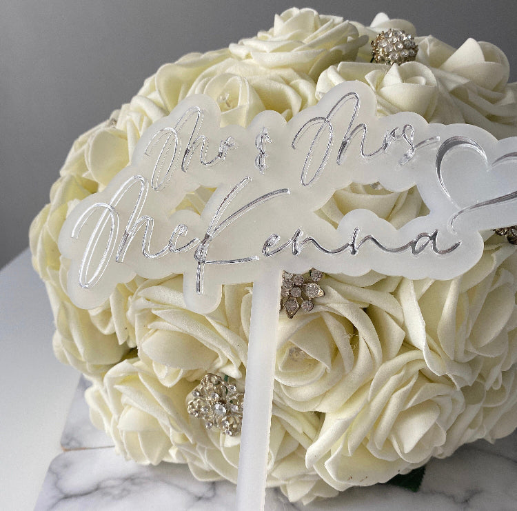 Double layer Wedding Cake topper with Mr and Mrs 'surname' shown next to a bridal bouquet.